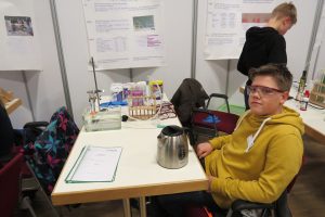 Egon mit seiner Arbeit über Oxi-Reiniger. Im Hintergrund Preisträger Matthis